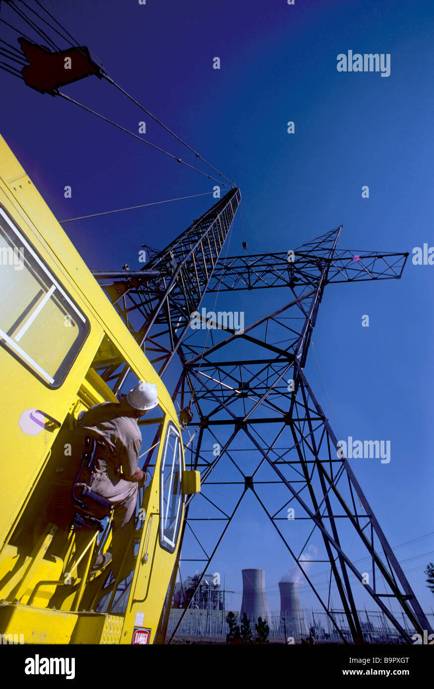 Il sollevamento con gru porzione della tensione alta torre in costruzione a Indiana di power plant. Foto Stock