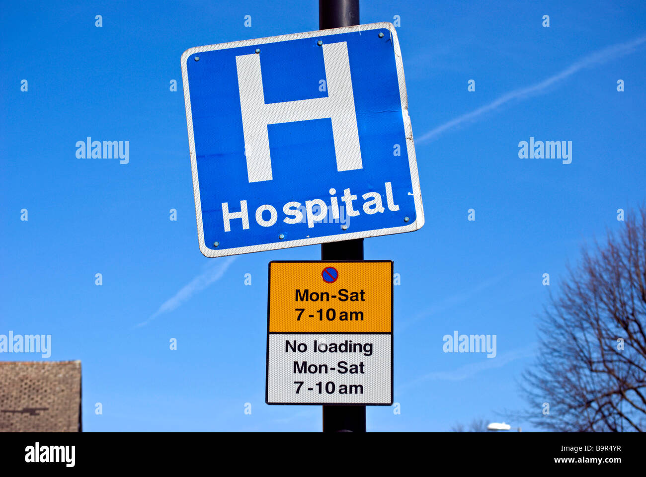 British blu e bianco segno dell'ospedale e i segni che mostra le restrizioni per il parcheggio Foto Stock