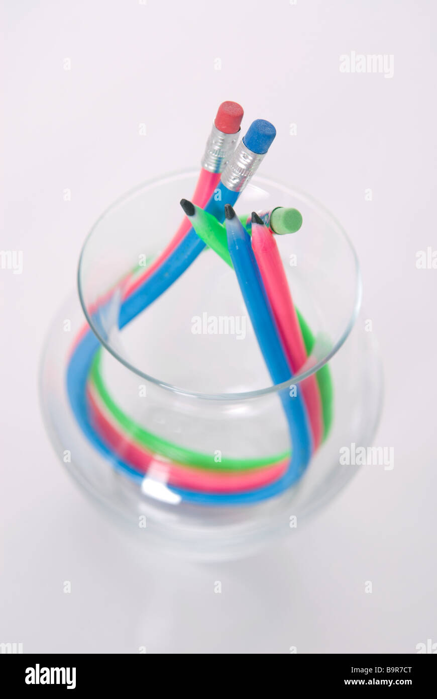 Gomma flessibile matite in un vaso di vetro su uno sfondo bianco Foto Stock
