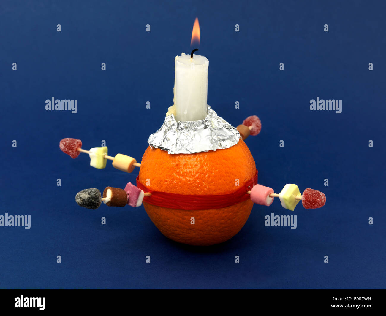Christingle Orange simboleggia il mondo, Candle Jesus Christ la luce del mondo, nastro rosso il sangue di Cristo e i quattro dolci l'angolo quattro Foto Stock