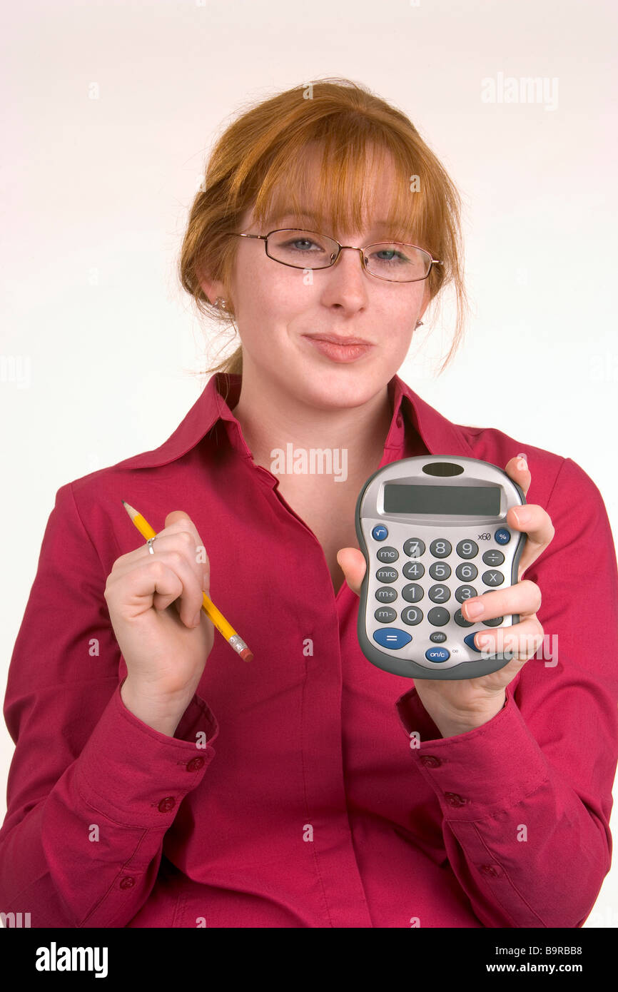 Una donna ha appena fatto un calcolo su un calcolatore e sembra contento del risultato Foto Stock