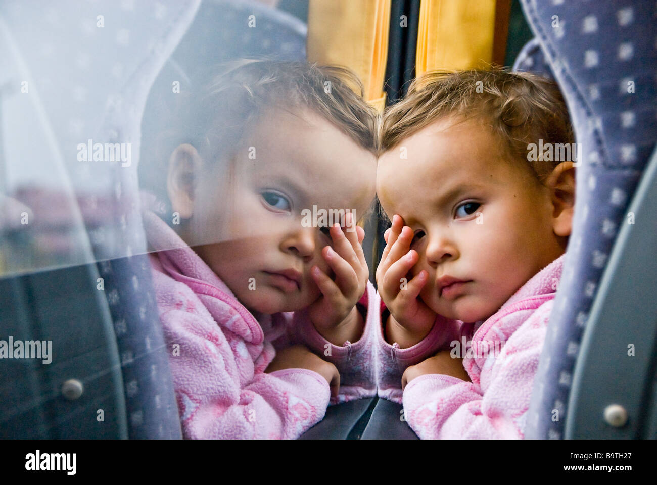 La ragazza e la sua riflessione sulla finestra che viaggiano su un autobus da Riga a Vilnius, Europa Foto Stock
