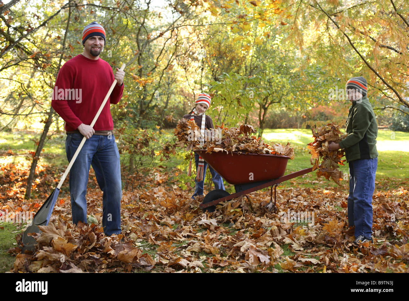 Padre e figli il prelievo di foglie di autunno Foto Stock
