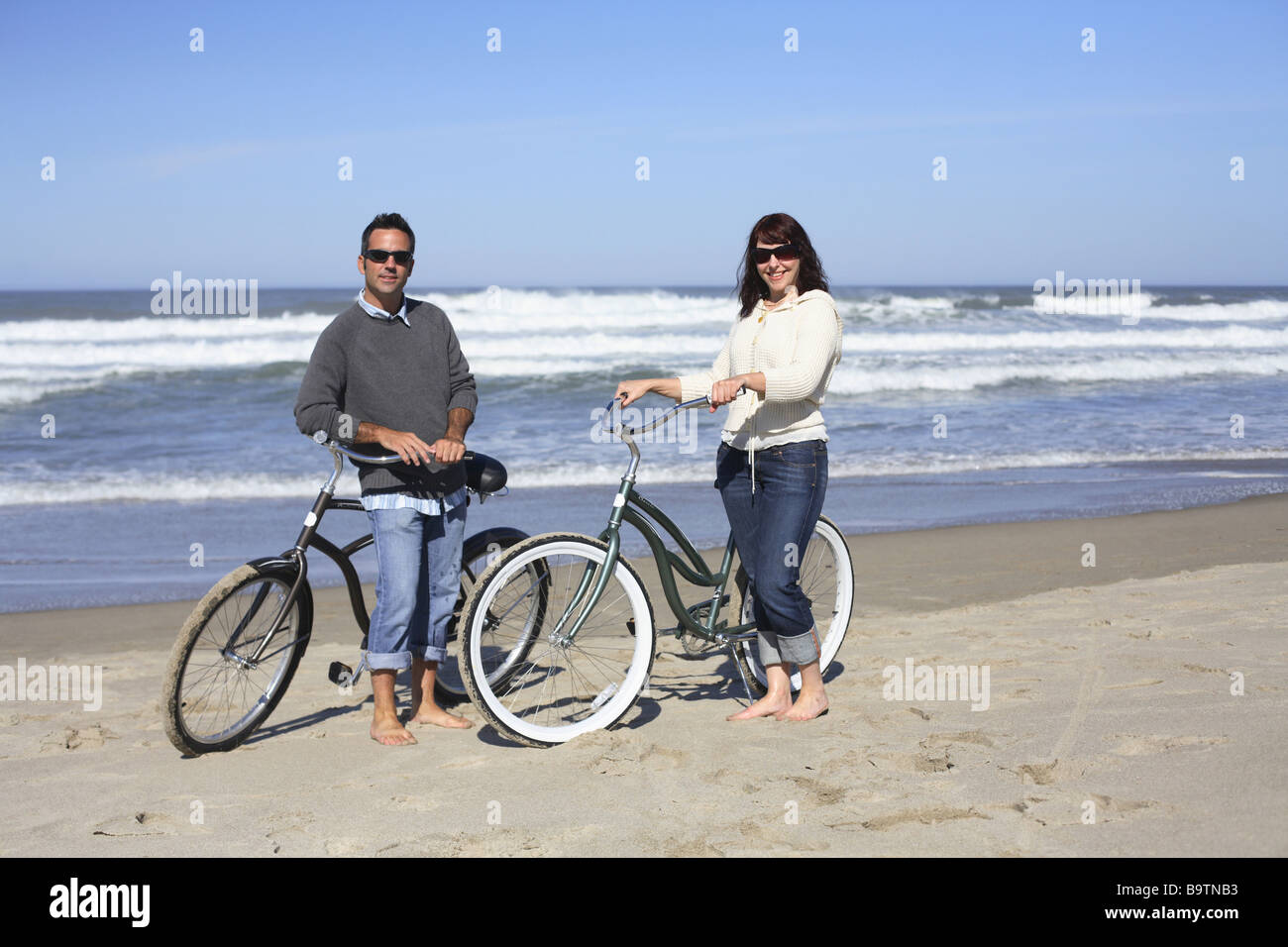 Coppia giovane con le biciclette presso la spiaggia Foto Stock