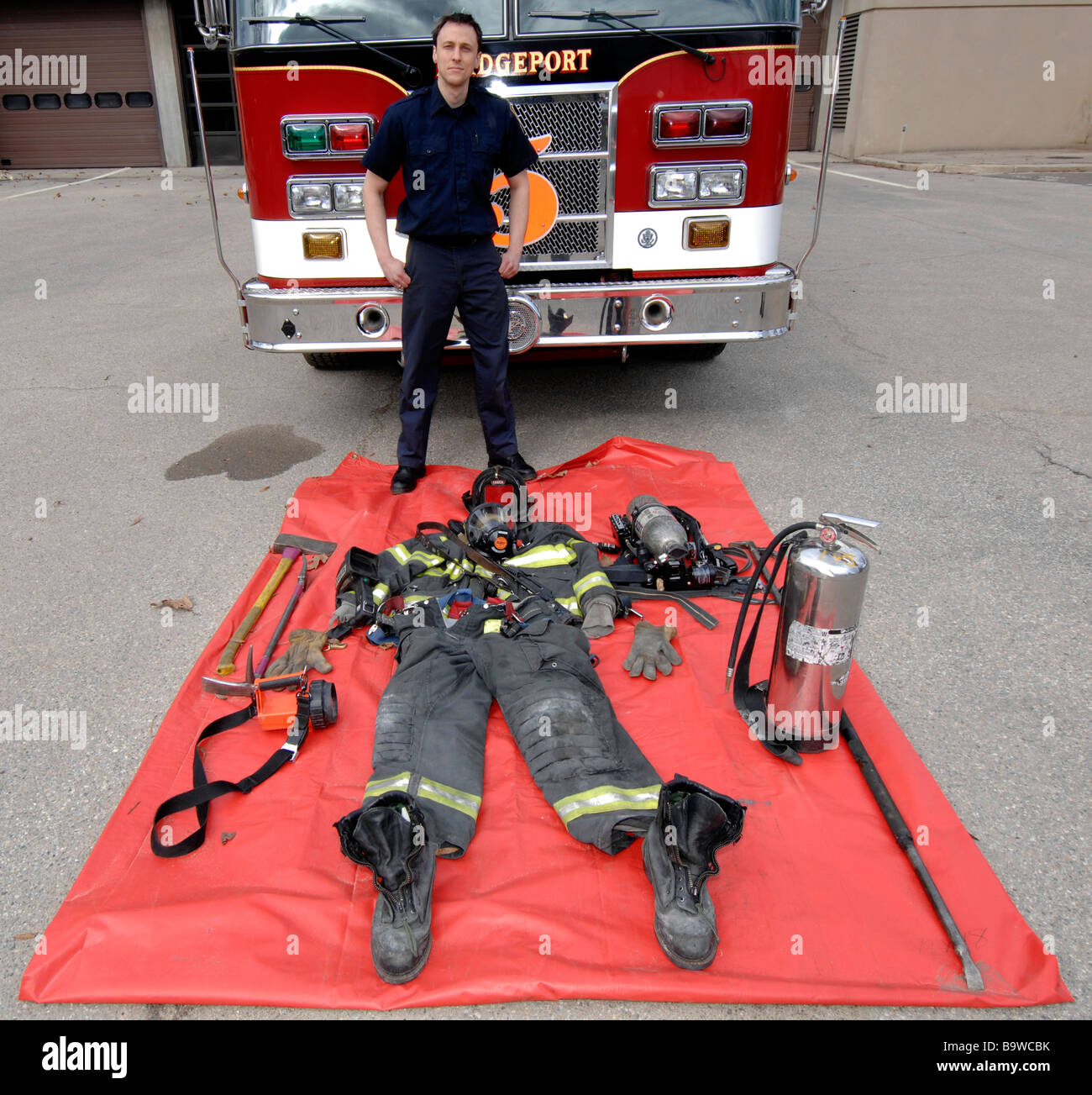 Vigile del fuoco con la marcia che egli assume per le chiamate per cui fuori davanti a lui Foto Stock