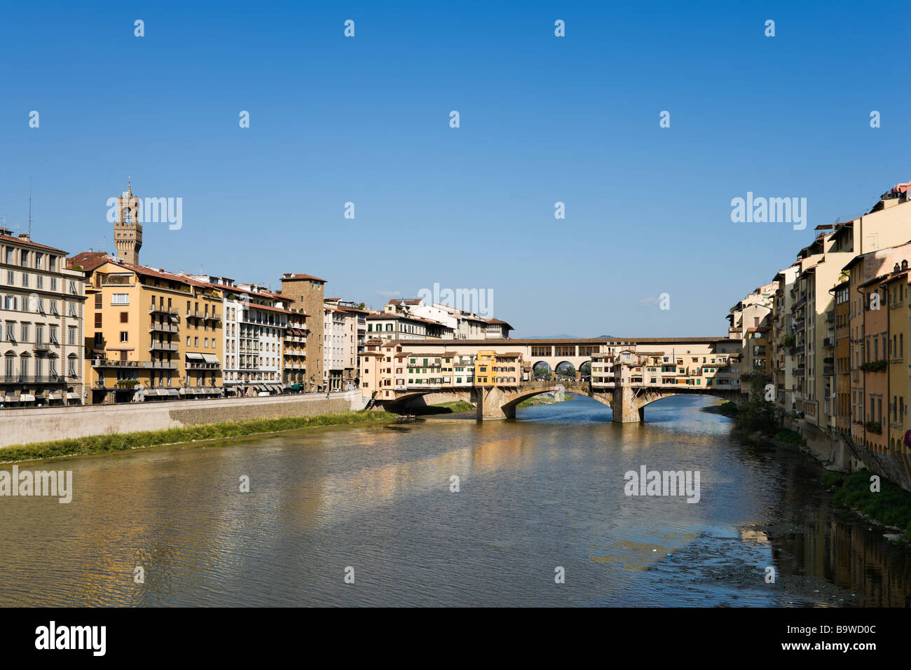 Il Ponte Vecchio e dal fiume Arno con la torre di Palazzo Vecchio che mostra sui tetti di Firenze, Toscana, Italia Foto Stock