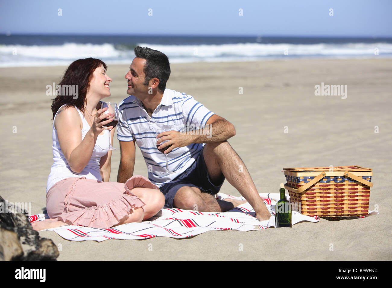 Giovane avente picnic sulla spiaggia Foto Stock