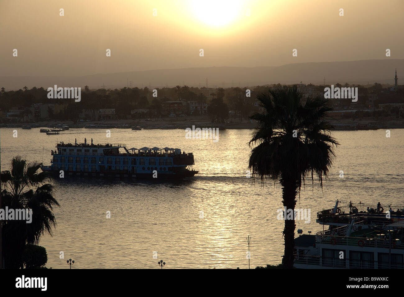 Una barca di crociera rende modo fino al Fiume Nilo a Luxor in Egitto durante il tramonto. Foto Stock