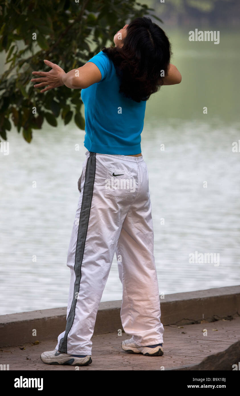 Donna pratica il Tai Chi si sposta al lago Hoan Kiem Hanoi Vietnam Foto Stock