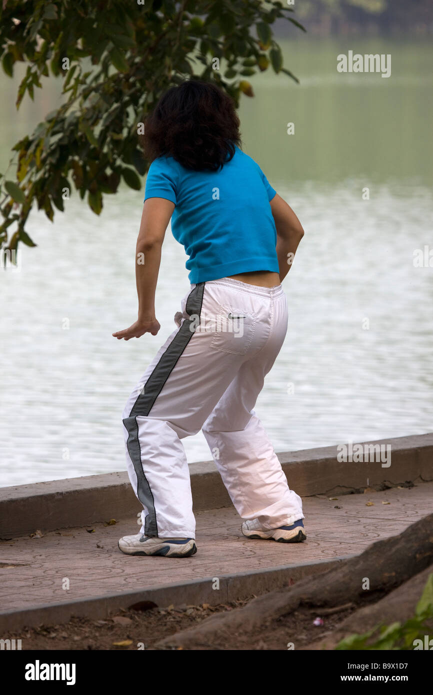 Donna pratica il Tai Chi si sposta al lago Hoan Kiem Hanoi Vietnam Foto Stock
