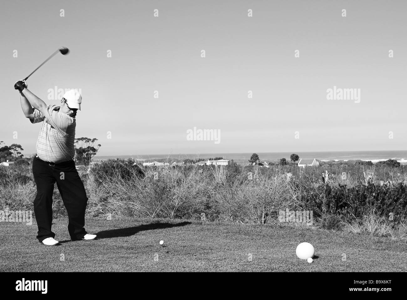 Un giocatore di golf giocare a golf su un movimento verde del golf club di testa ma è messa a fuoco Foto Stock