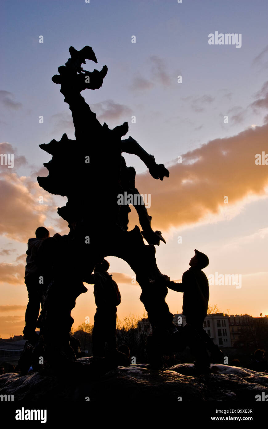 I bambini guardando curioso ad una statua di un drago al tramonto. Cracovia in Polonia, Europa Foto Stock