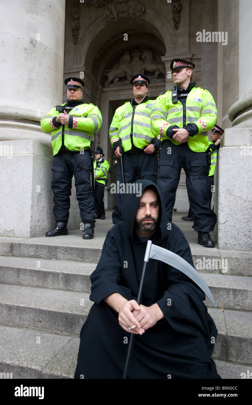 G20 di Londra di dimostrazione fila di funzionari di polizia dietro Grim Reaper Foto Stock