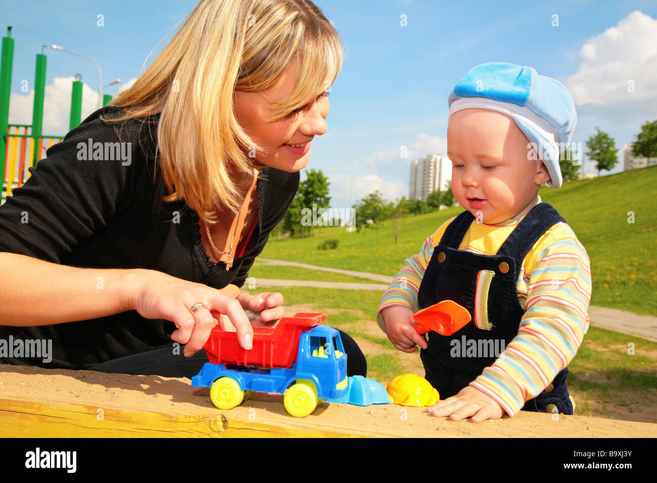 La madre gioca con il bambino con il giocattolo auto Foto Stock
