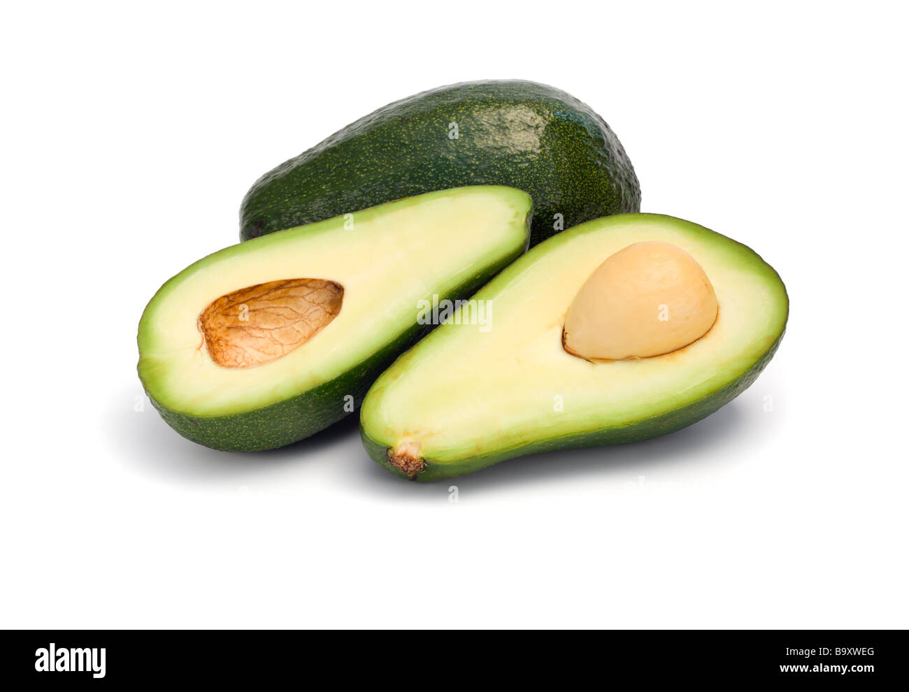 Intero e dimezzato frutto di Avocado isolato su bianco Foto Stock