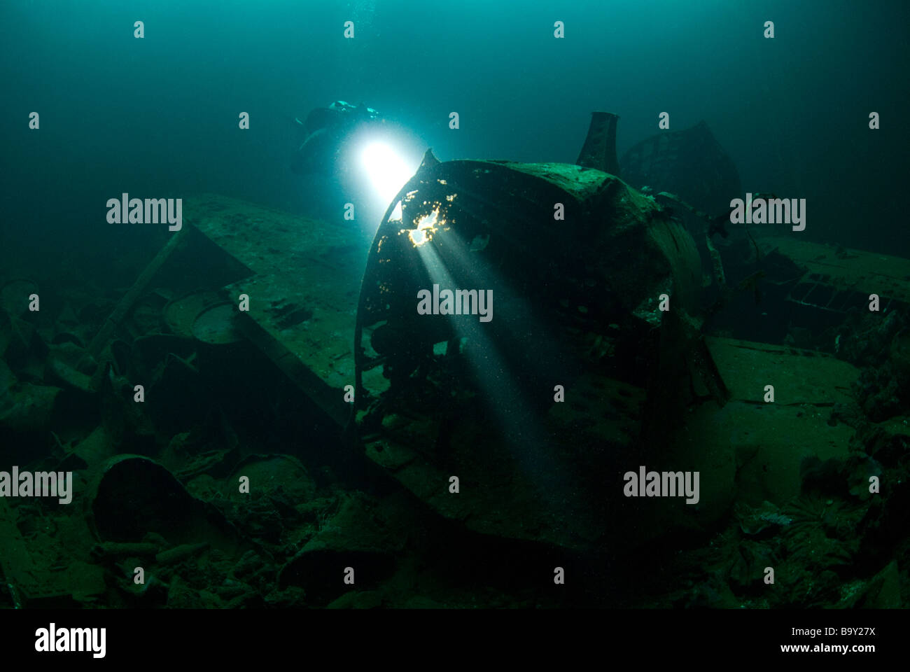 Un subacqueo brilla la loro luce attraverso i fori nella fusoliera di uno Zero giapponese da combattimento aereo nella stiva dell'Fujikawa Maru Foto Stock