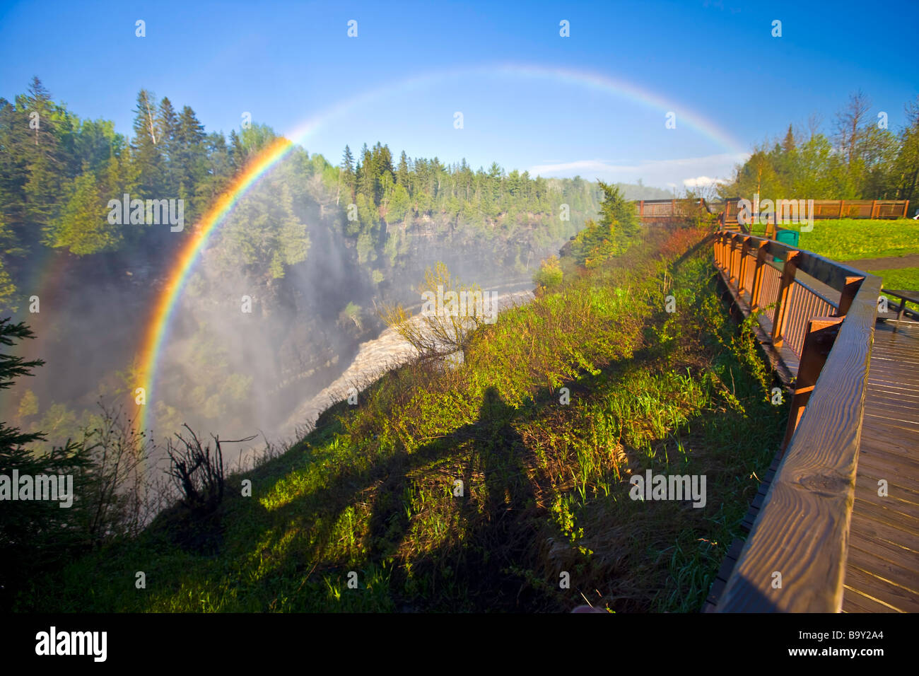 Rainbow nella nebbia sopra la passeggiata in corrispondenza di Kakabeka Falls (aka Niagara del Nord) lungo il fiume Kaministiquia. Foto Stock