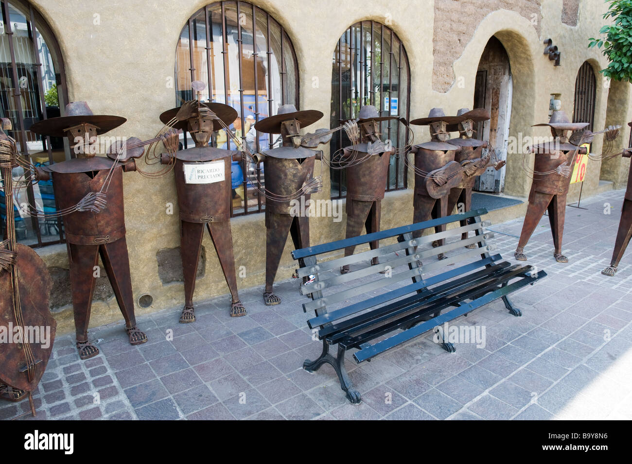 Un gruppo di stagno Marichi riproduzione di statue seranade un sedile in Tlaquepaque Foto Stock