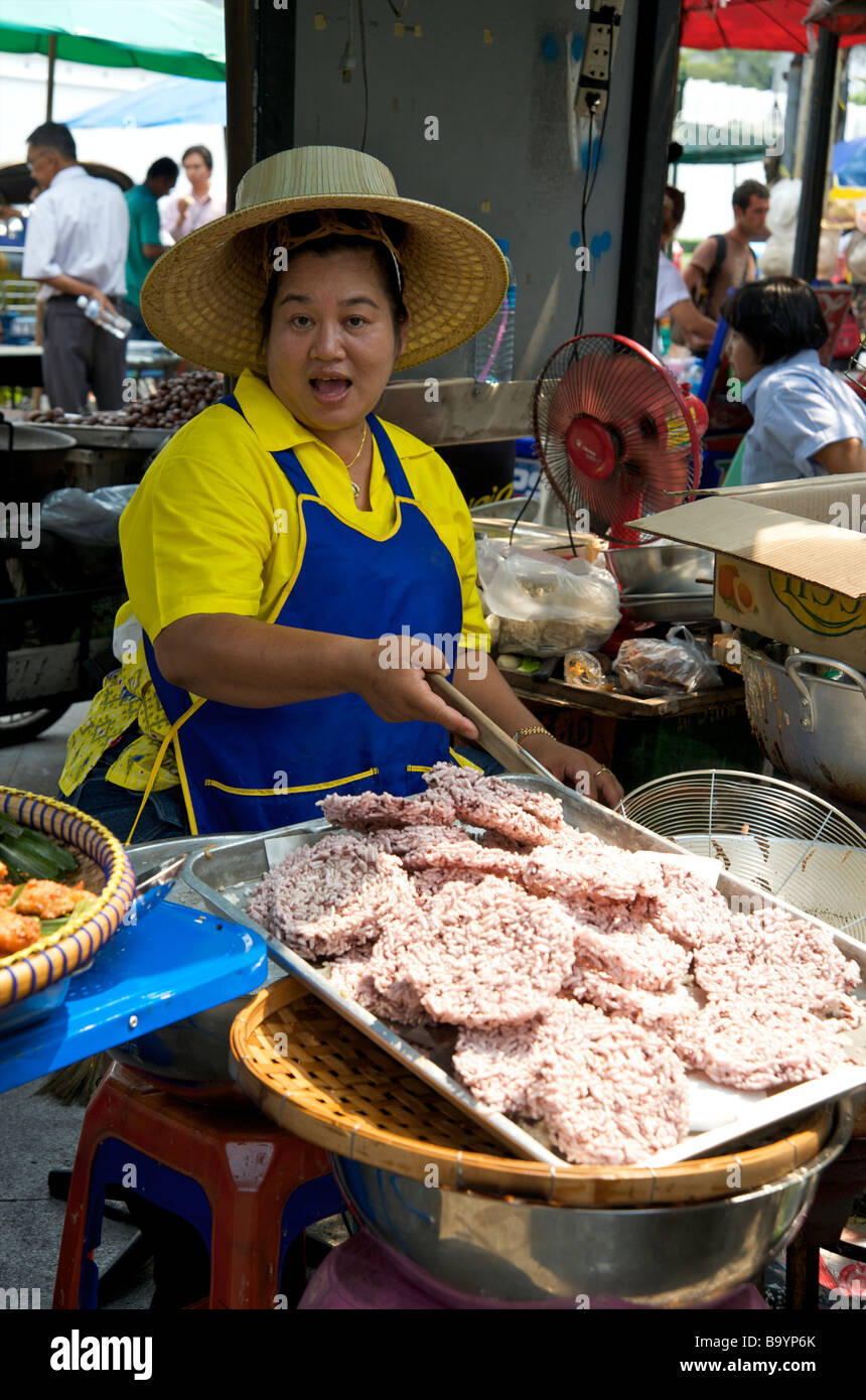 Una donna tailandese felice friggere torte di riso sulla sua strada Bangkok stallo Thailandia Foto Stock