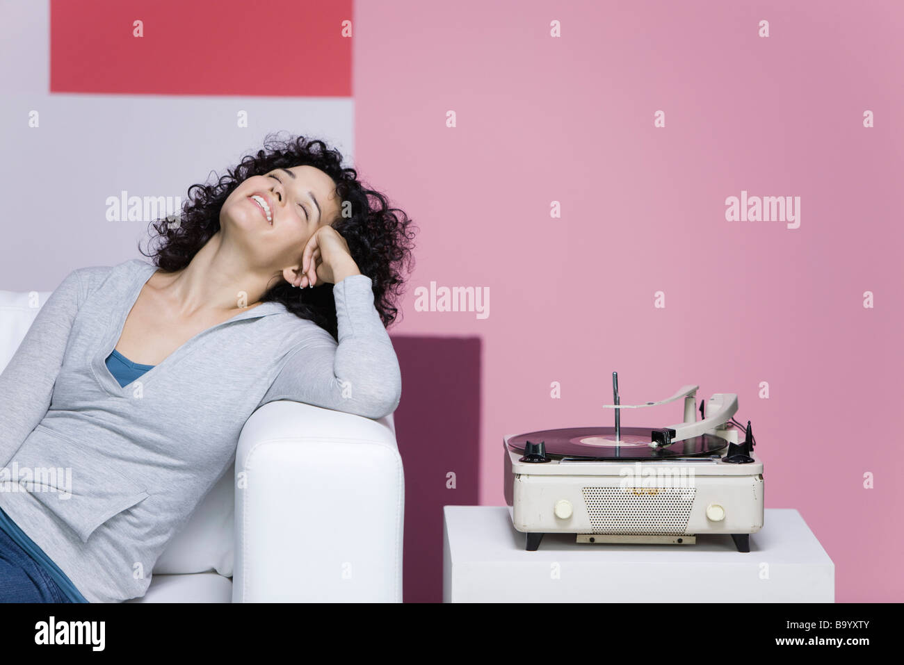 Donna godendo di musica, ascoltare un vecchio stile record giocatore Foto Stock