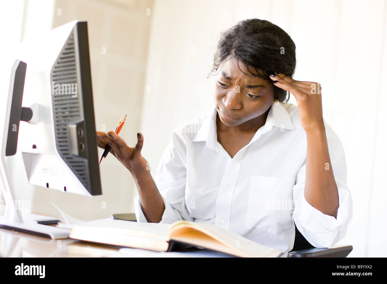 Donna etnica al computer Foto Stock