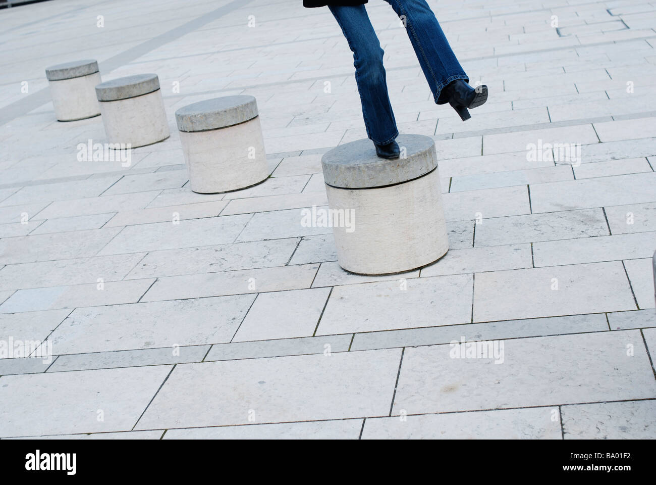Donna concettuale saltare da un pilastro al pilastro. Foto Stock
