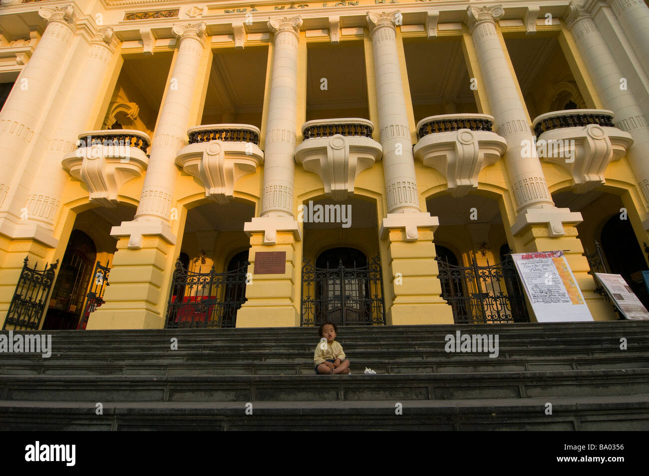 Ragazzo seduto sui gradini davanti alla Opera House di Hanoi Vietnam Foto Stock
