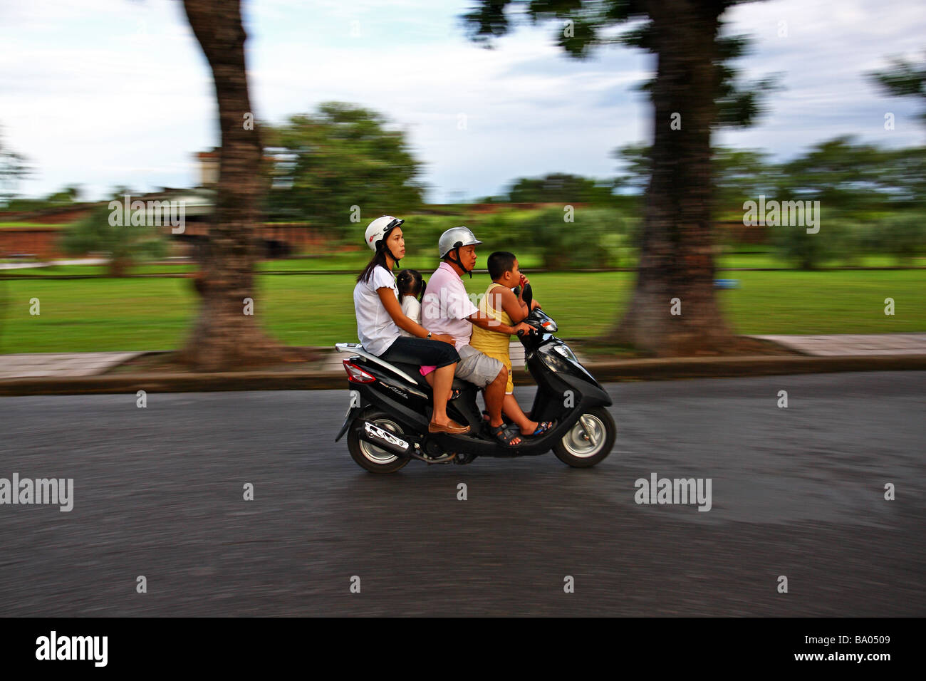 Scena di strada. Una famiglia su uno scooter a motore. La tonalità del Vietnam. Il Sud Est asiatico Foto Stock