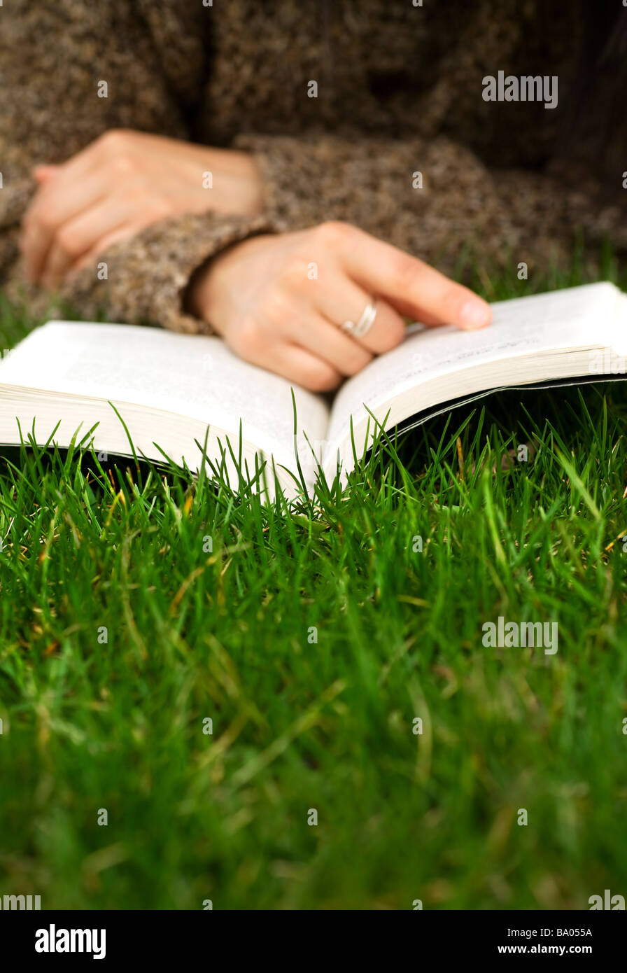 Persona la lettura di un libro sull'erba Foto Stock