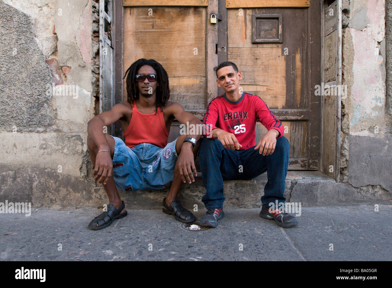 Due giovani cubani, uomini rilassante per la strada di Santiago de Cuba Foto Stock