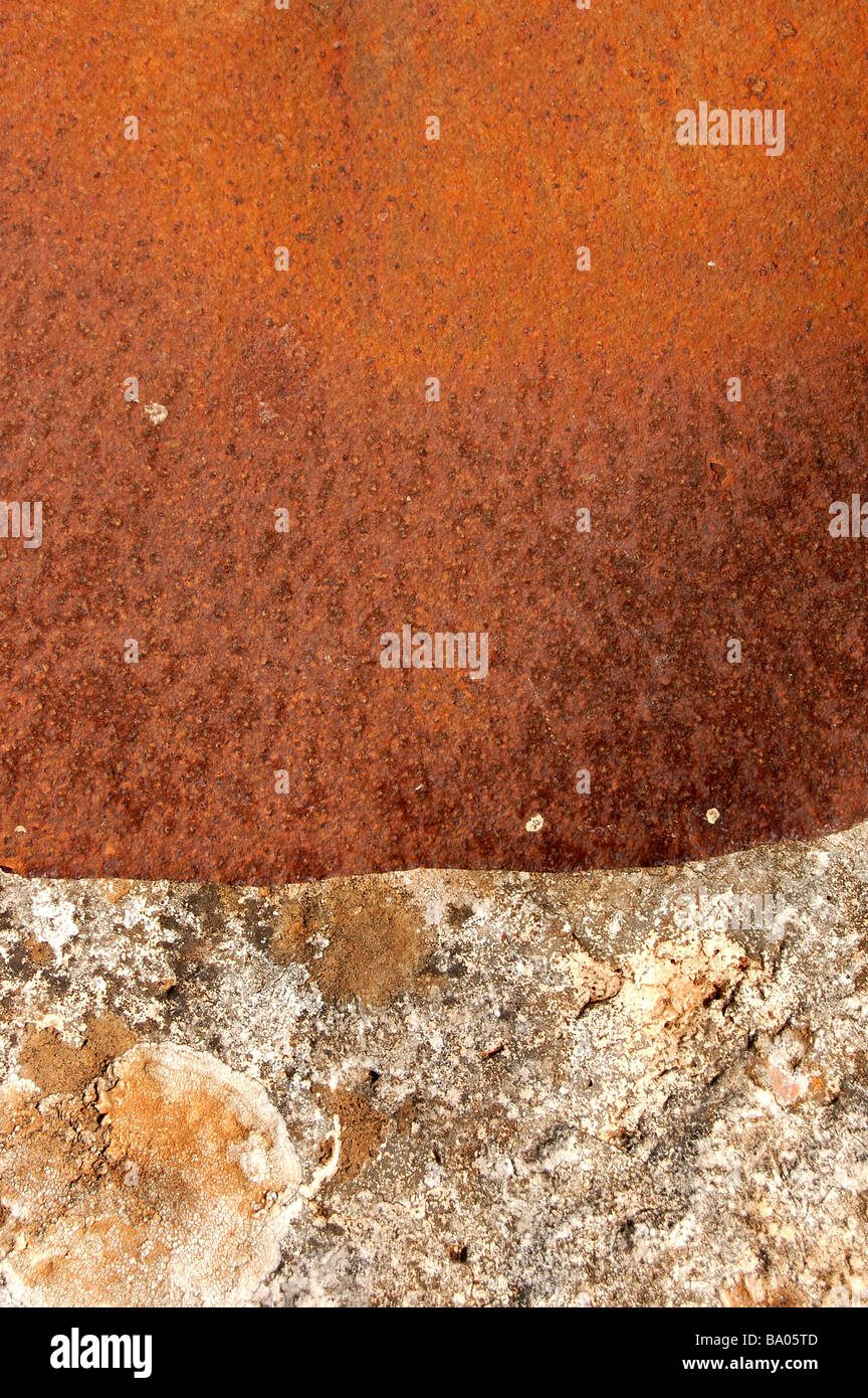 Rusty foglio di metallo che copre l'apertura di un antico pozzo in pietra. Foto Stock