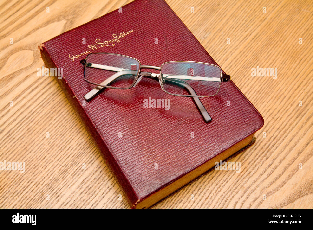 Un paio di occhiali per leggere in appoggio su un libro di poesie Longfellow. Foto Stock