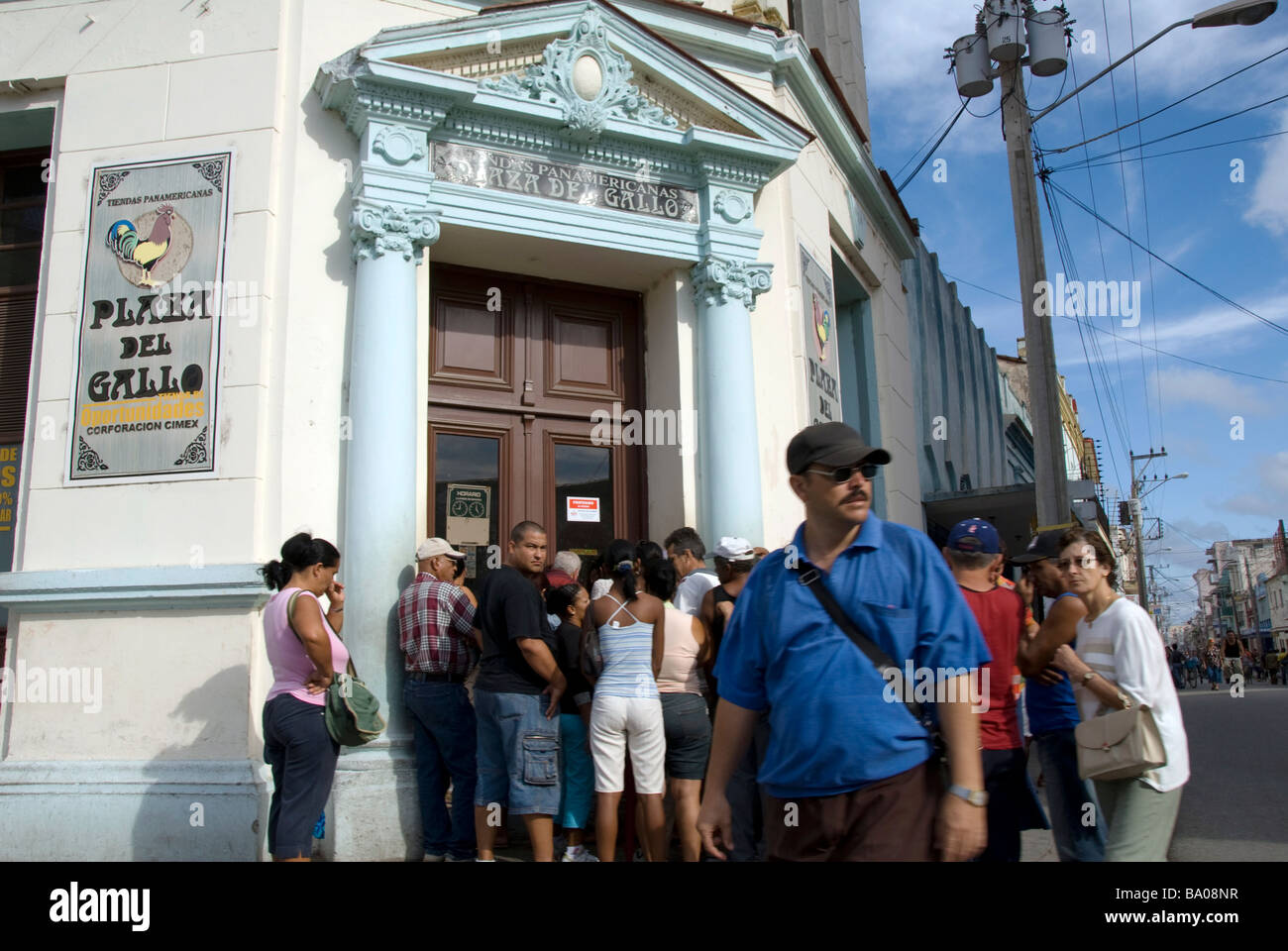 Il popolo cubano in piedi in una linea vicino a un negozio Foto Stock