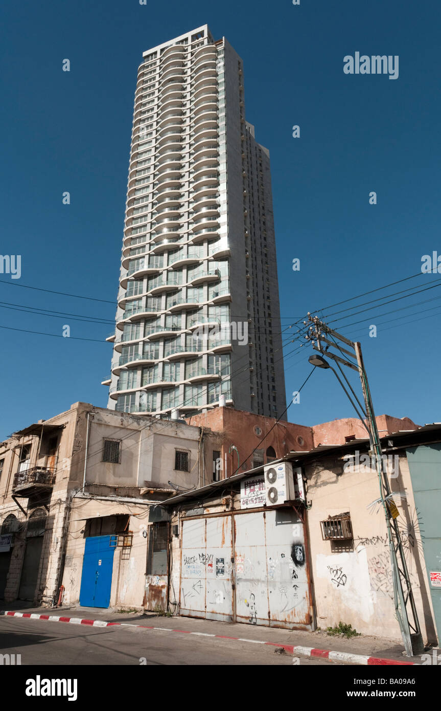 Nuovo alto edificio di appartamenti visto da un fatiscente parte della città di Tel Aviv Israele Foto Stock