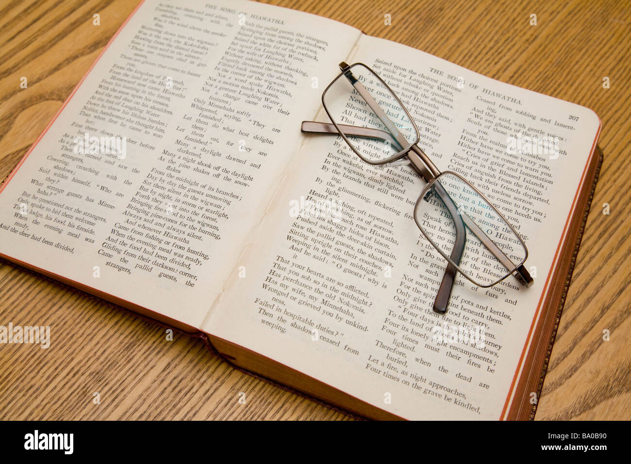Un paio di occhiali per leggere in appoggio su un libro di poesie Longfellow. Foto Stock