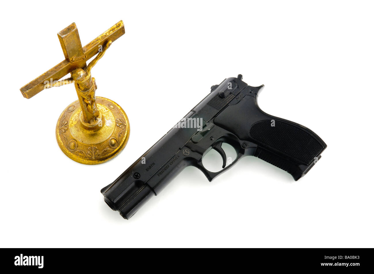 Pistola accanto a un antico Crocifisso di ottone nota pistola è imitazione giocattolo e contrassegnati di conseguenza Foto Stock