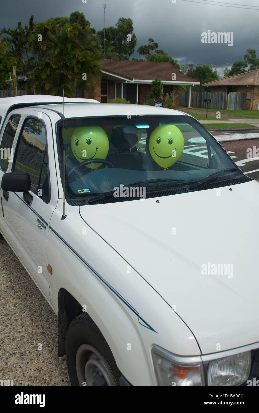 Faccina felice palloncini in auto Foto Stock