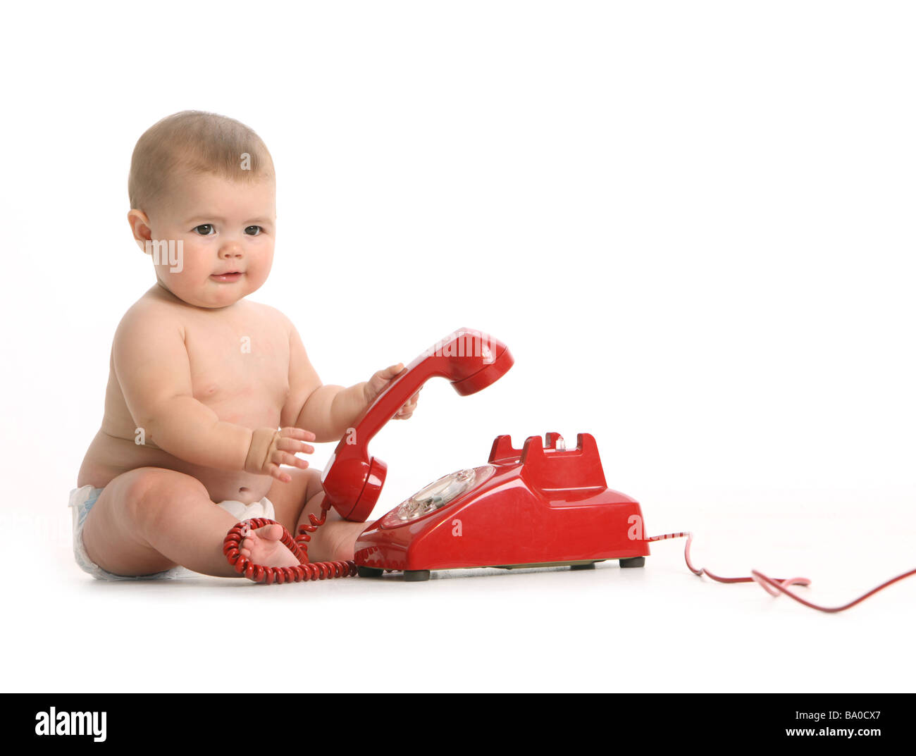 Bambino con telefono rosso su sfondo bianco Foto Stock