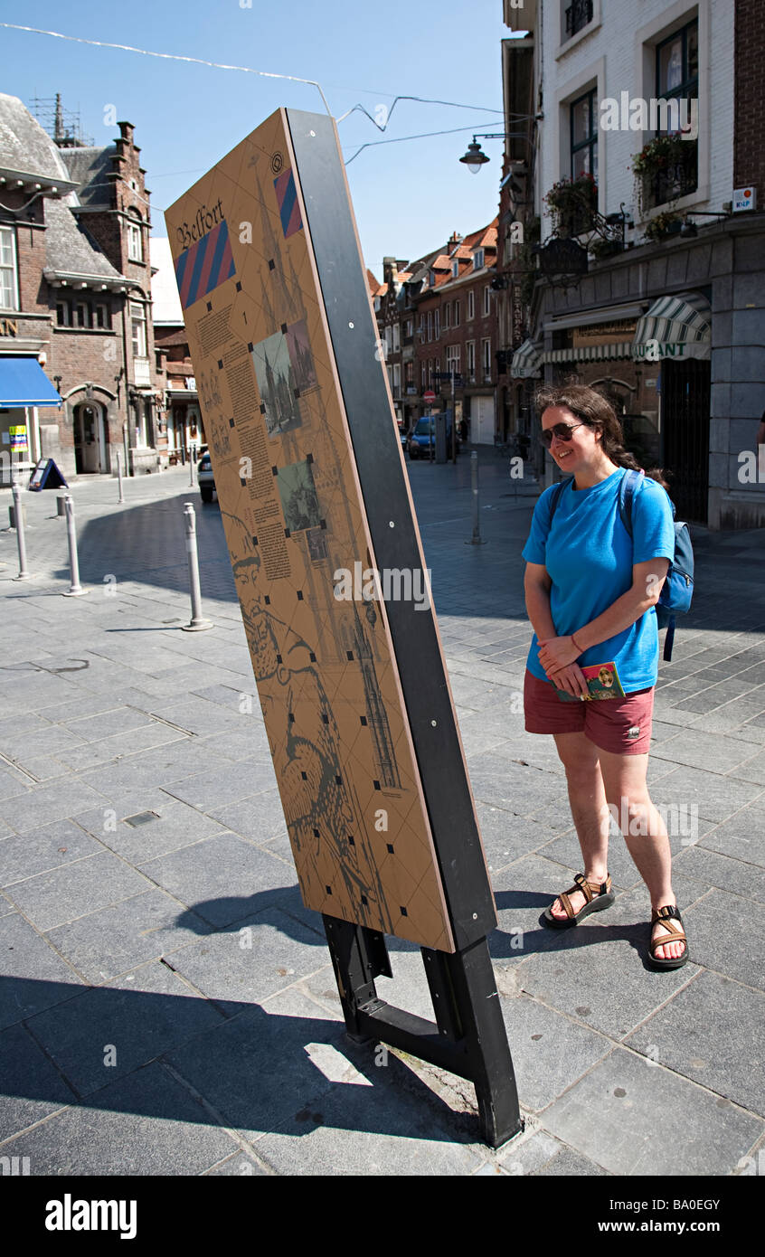 Sorridente turista femminile per la lettura di informazioni segno Tournai Belgio Foto Stock