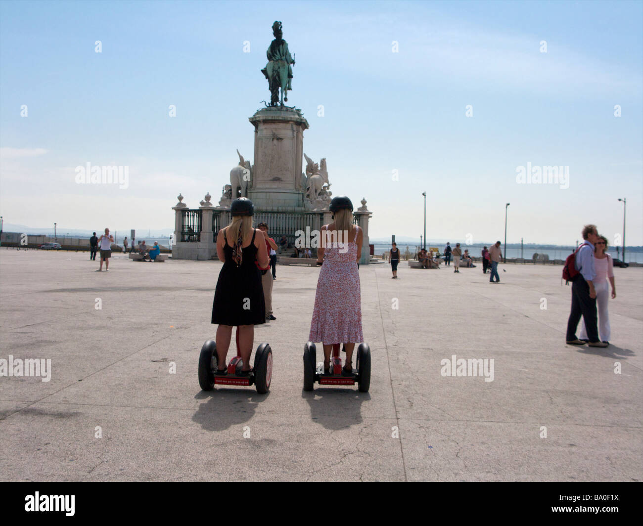 Due turisti femmina ride il 'Segway Personal Transporter' nella piazza di Lisbona Portogallo Foto Stock