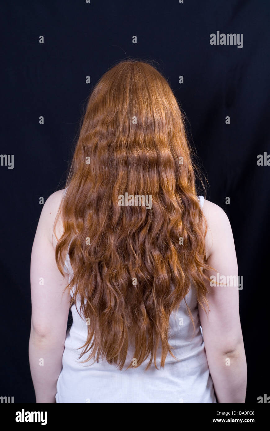 Vista posteriore di una giovane donna con lunghi capelli allo zenzero Foto Stock
