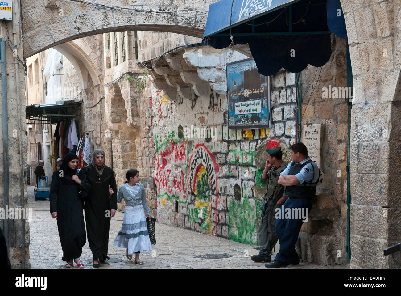 Israele. Gerusalemme la città vecchia. Muslem trimestre. 3 le donne palestinesi a piedi passato 2 poliziotti israeliani Foto Stock