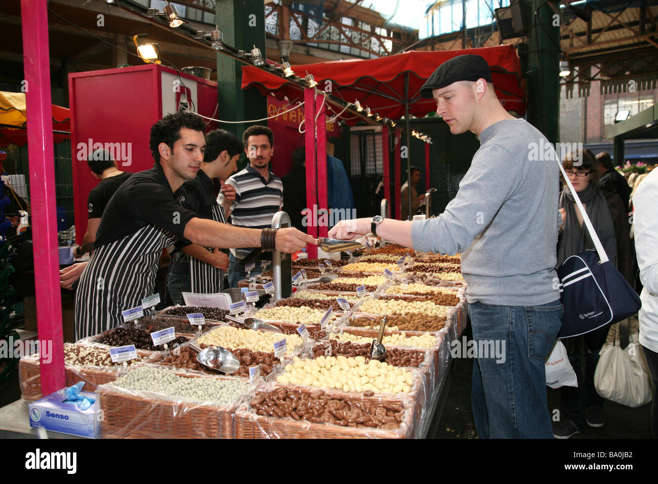 Uomo cerca ricoperta di cioccolato uvetta prima di acquistare a London Borough Market Foto Stock