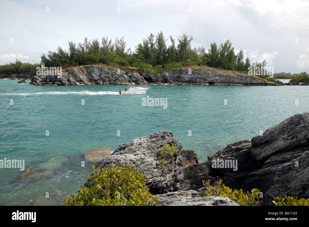 Shot presi da cancelli fort, mostrando una piccola imbarcazione a motore che passa attraverso la città tagliata, vicino alla città di St George, Bermuda Foto Stock