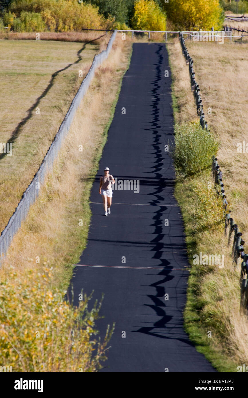 Donna che cammina per esercitare sul paese rurale lane near Jackson Wyoming USA Foto Stock