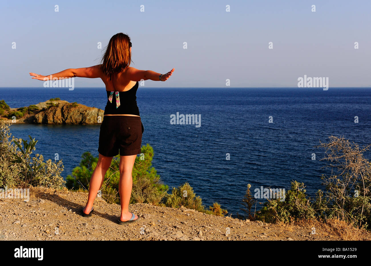 Una giovane donna che guarda sul mare Foto Stock