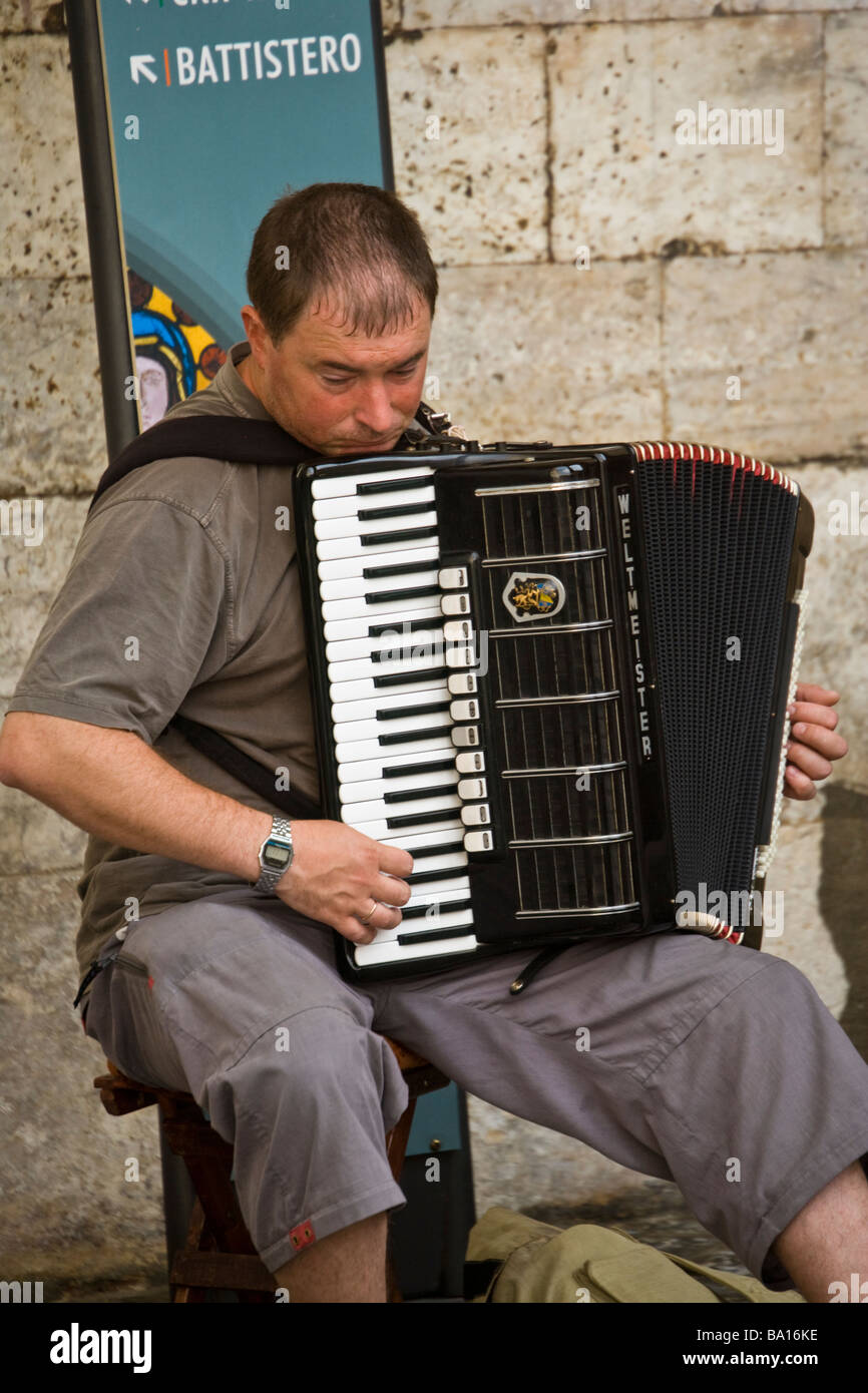 Lettore di fisarmonica musicista di strada in Piazza Jacopo della Quercia, Siena, Toscana, Italia Foto Stock