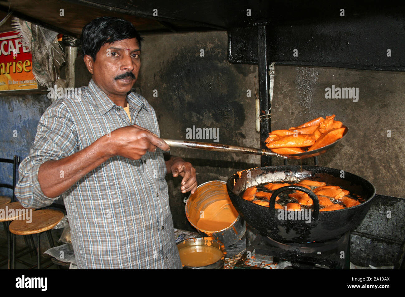 Uomo indiano Samosa di frittura in corrispondenza di un bordo strada Dhaba in stallo Foto Stock