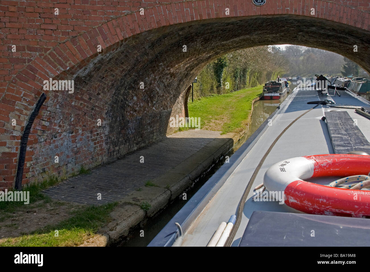 Longboat barca passando sotto il ponte sul Grand Union Canal Foto Stock