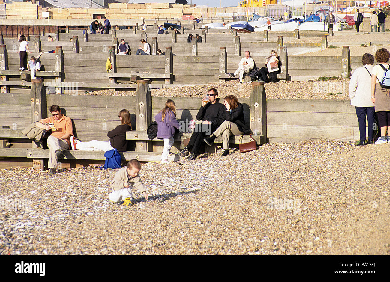 Whitstable, North Kent, coloro che godono di una calda primavera domenica pomeriggio sulla spiaggia. Foto Stock